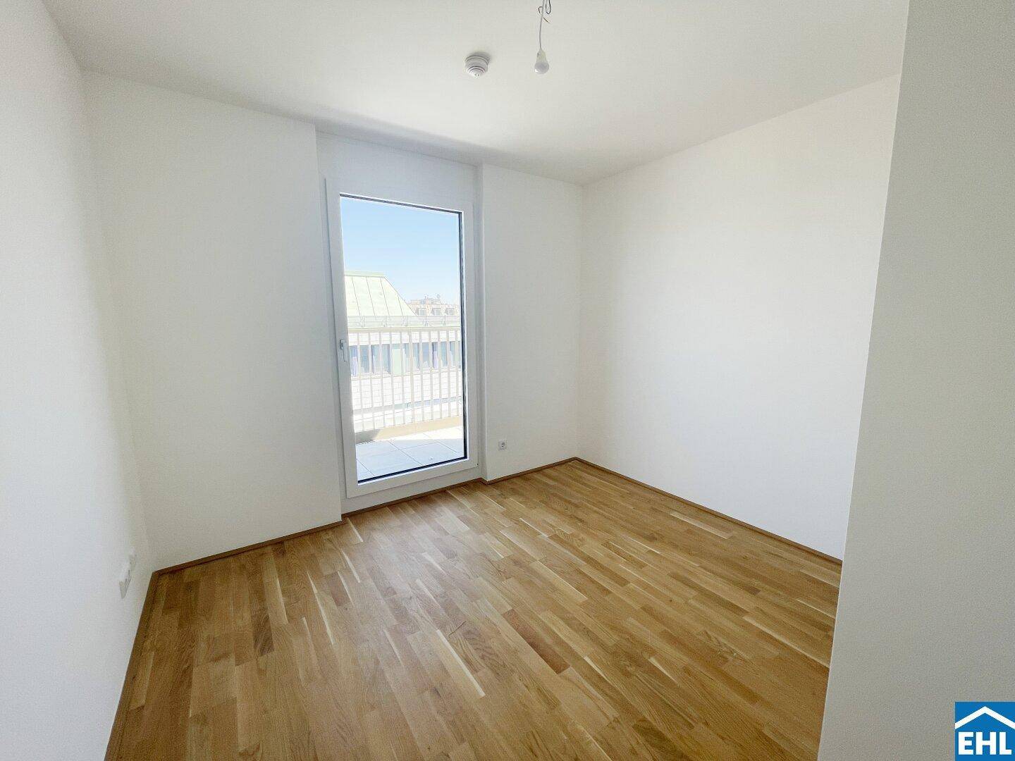 Freundliches Zimmer mit Holzboden und Zugang zu einem Außenbereich.