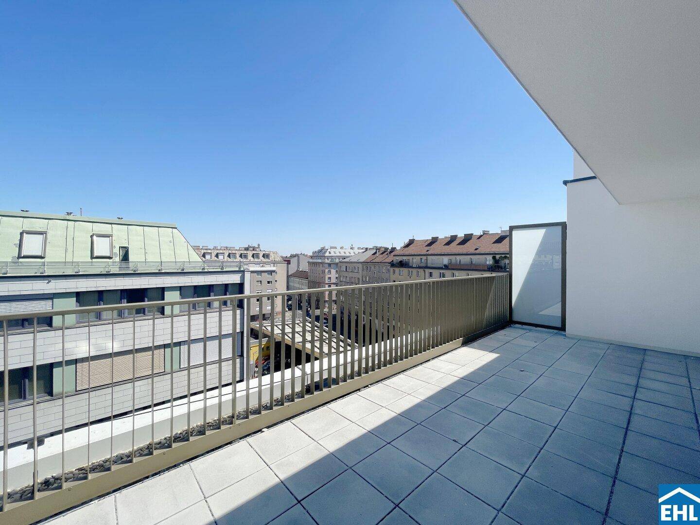 Geräumiger Balkon mit Fliesen und Blick auf die umliegende Stadtlandschaft.