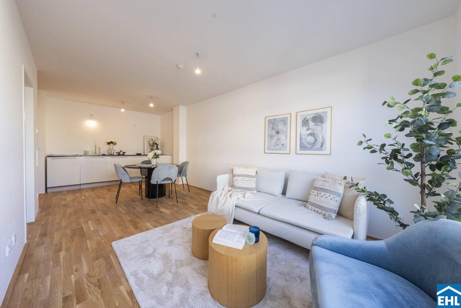 Gemütlicher Wohnbereich mit Sofa, Couchtischen und Blick auf die offene Küchenzeile.