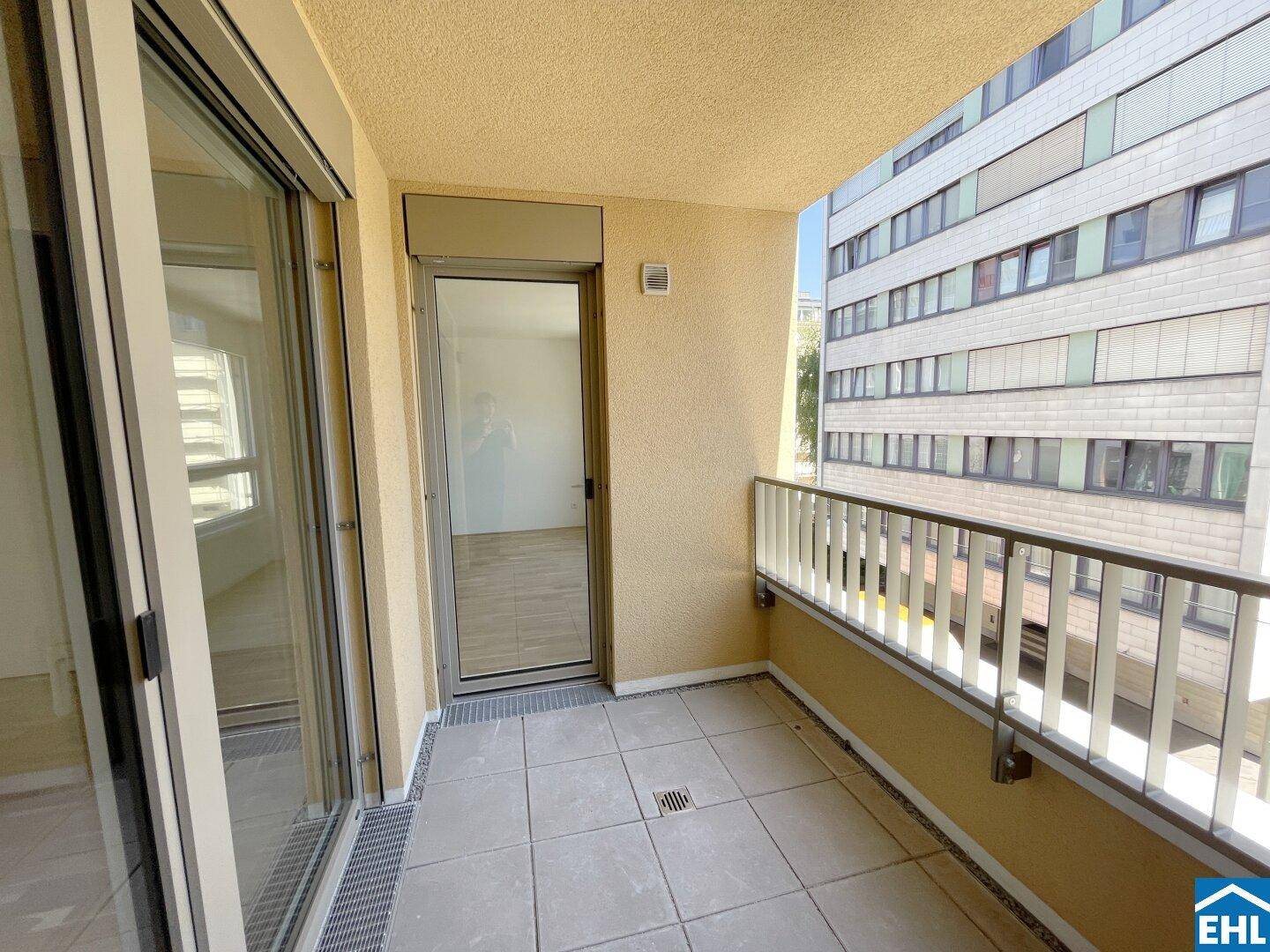 Geräumiger Balkon mit Fliesenboden und Zugang zu den Innenräumen der Wohnung.