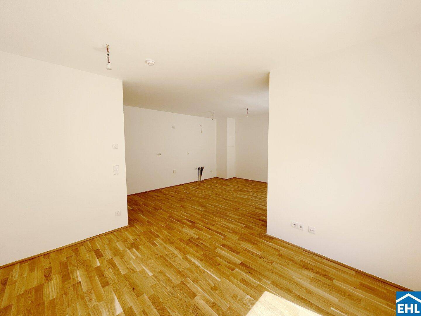 Heller Innenraum mit neuem Parkettboden und weißen Wänden, ideal für ein modernes Wohnkonzept.