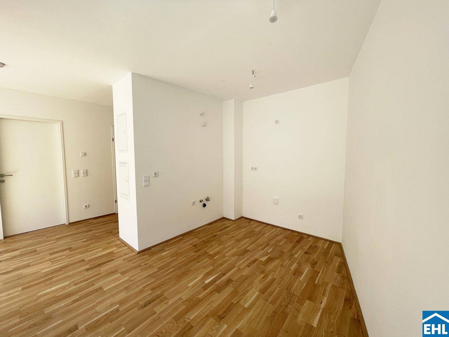 Leerer Raum mit Parkettboden und Wandanschlüssen, bereit für individuelle Gestaltung.