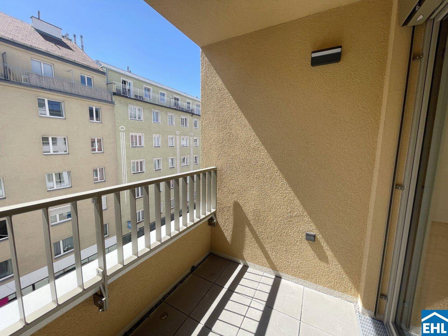 Heller Balkon mit Fliesen und Metallgeländer, bietet einen Ausblick auf die Nachbarschaft.