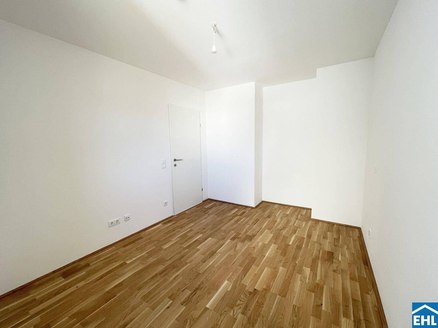 Geräumiges Schlafzimmer mit Parkettboden und viel Tageslicht, bereit zur Einrichtung.