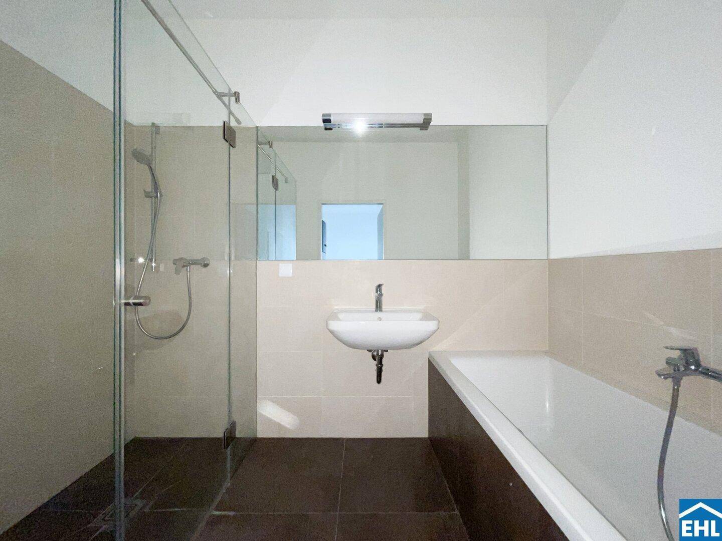 Modernes Badezimmer mit begehbarer Dusche, Badewanne, Einzelwaschbecken und großem Spiegel.