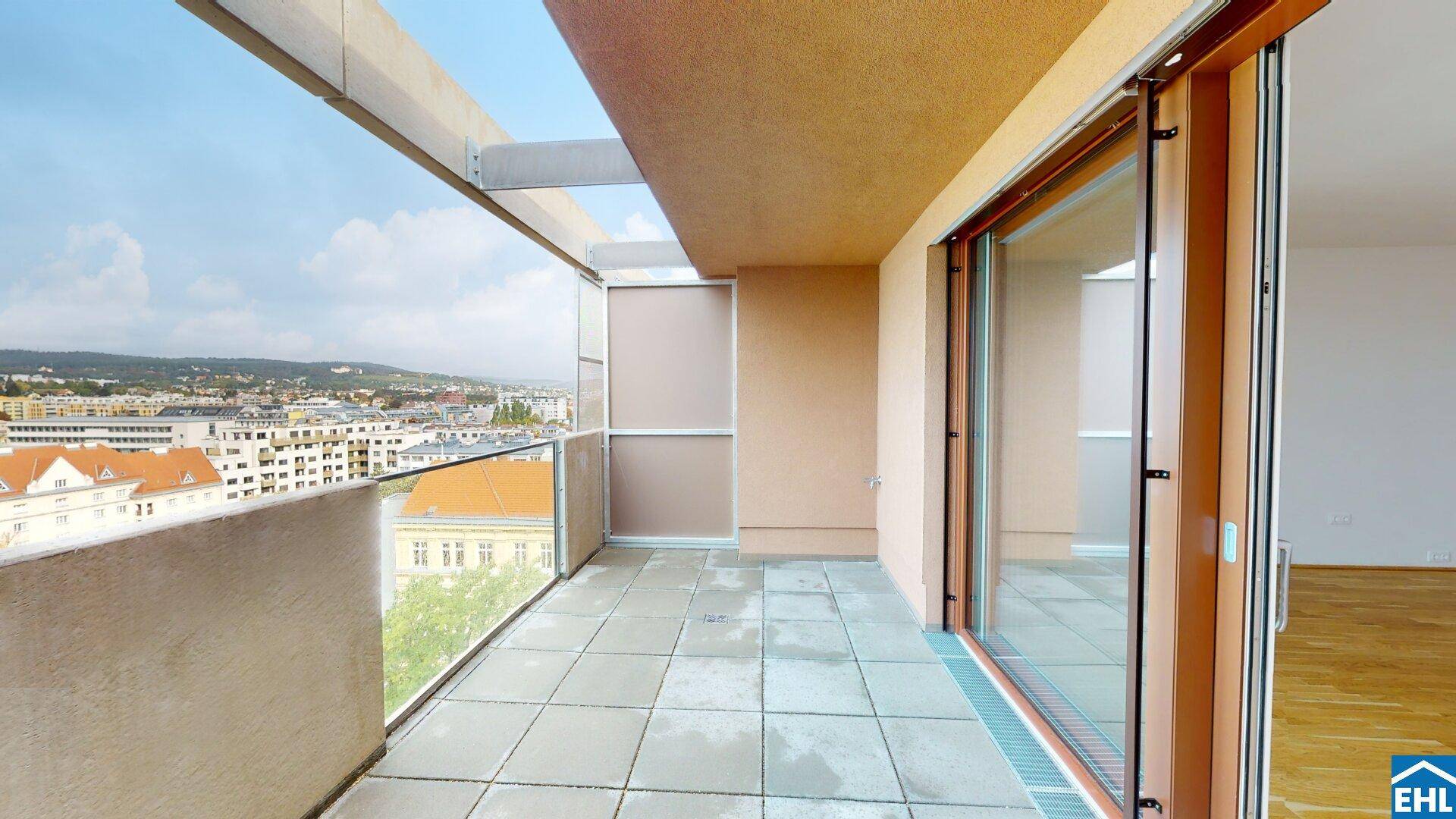 Geräumiger Balkon mit Fliesenboden und weitem Blick über die Stadtlandschaft und umliegende Gebäude.