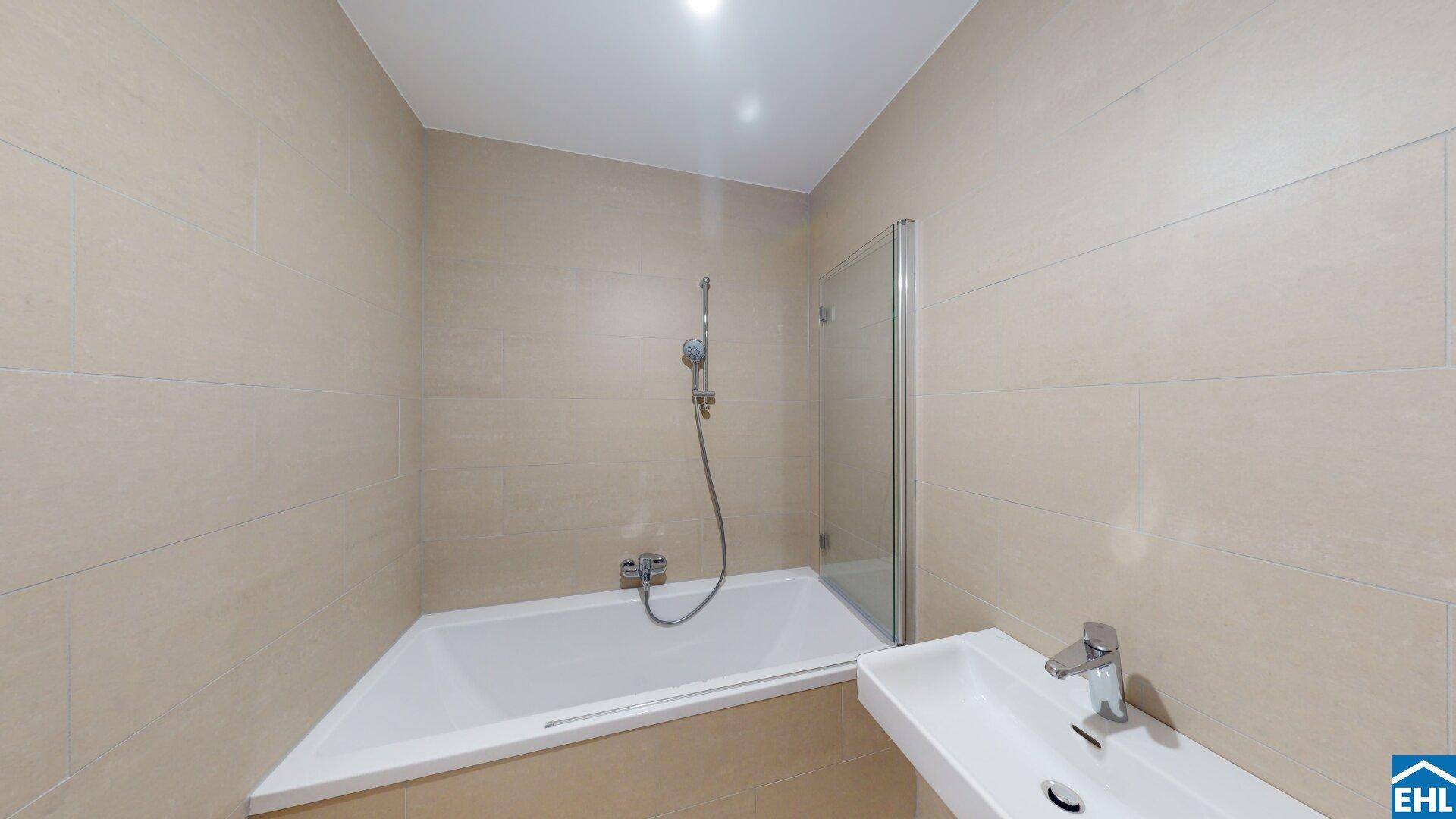 Modernes Badezimmer mit beigefarbenen Fliesen, einer Eckbadewanne und einer integrierten Dusche.