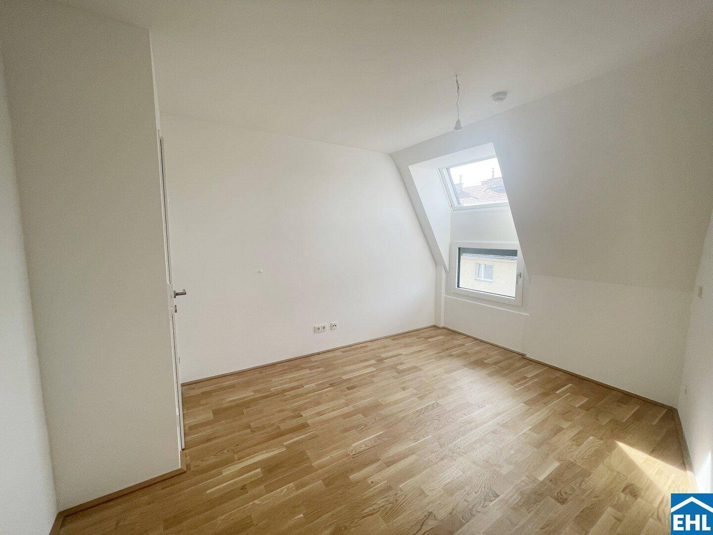 Gemütliches Schlafzimmer mit Holzboden und schrägen Wänden, ideal für ein Dachgeschoss.