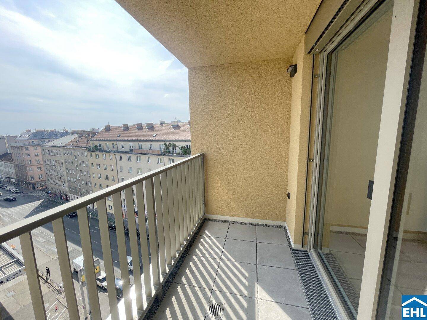 Heller Balkon mit Fliesenboden und Metallgeländer, bietet einen weiten Blick über die Stadt.