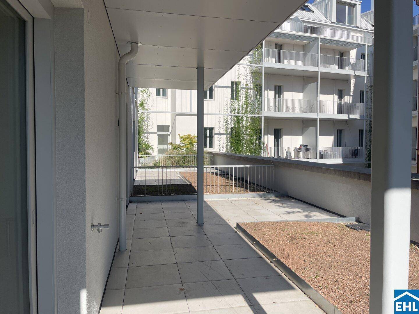Geräumige Terrasse mit Fliesenboden und Blick auf die umliegenden Gebäude.