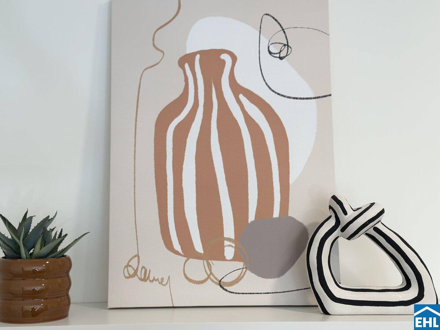 Abstrakte Kunst und moderne Dekoration auf einem Regal, ergänzt durch eine kleine Pflanze.