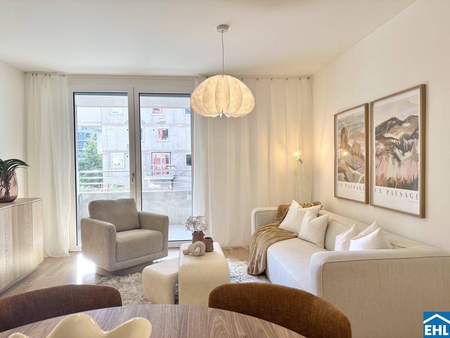 Helles Wohnzimmer mit modernem Design, bequemen Möbeln und Zugang zum Balkon.