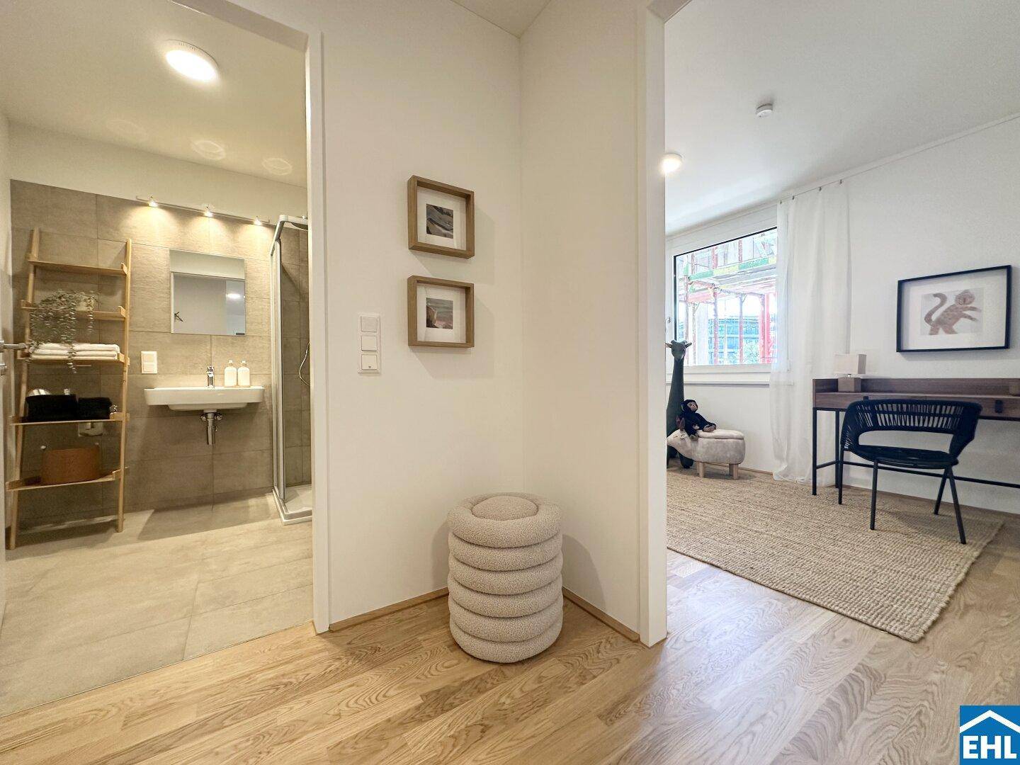 Heller Flur mit Holzboden, der zu einem modernen Badezimmer und einem weiteren Raum führt.