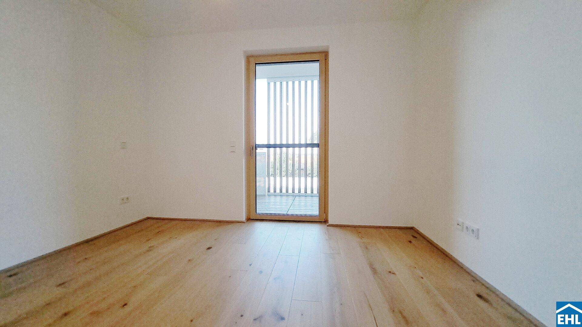 Helles Zimmer mit Holzboden und Balkontür, ideal als Schlafzimmer oder Arbeitszimmer nutzbar.