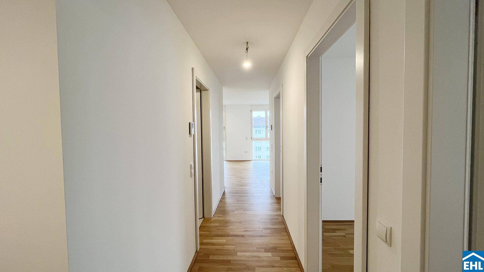 Langer, heller Flur mit Holzboden, der einen einladenden Zugang zu den Wohnbereichen bietet.
