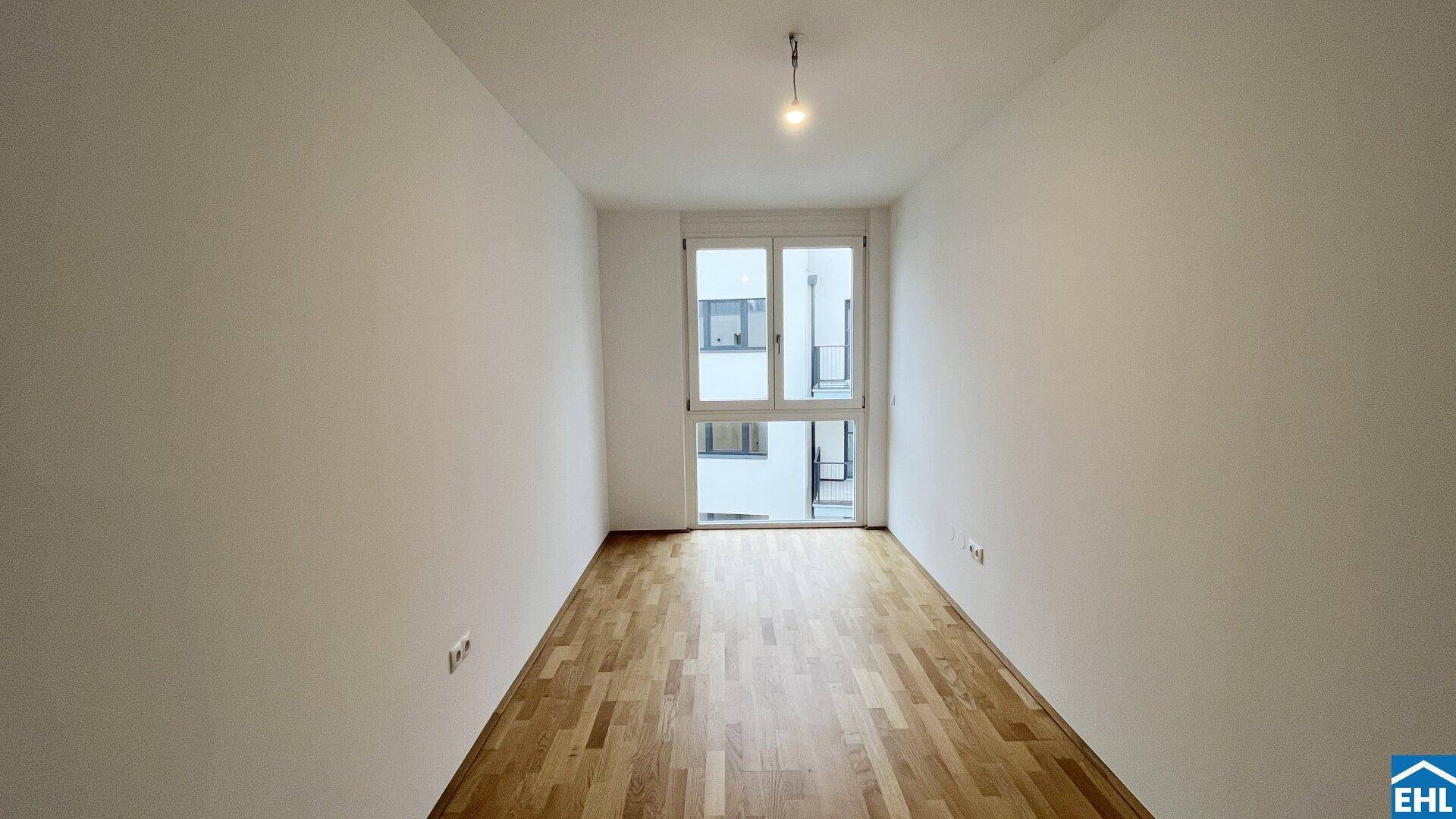 Helles, unmöbliertes Schlafzimmer mit Holzboden und Zugang zu einem Balkon, bereit für neue Bewohner.