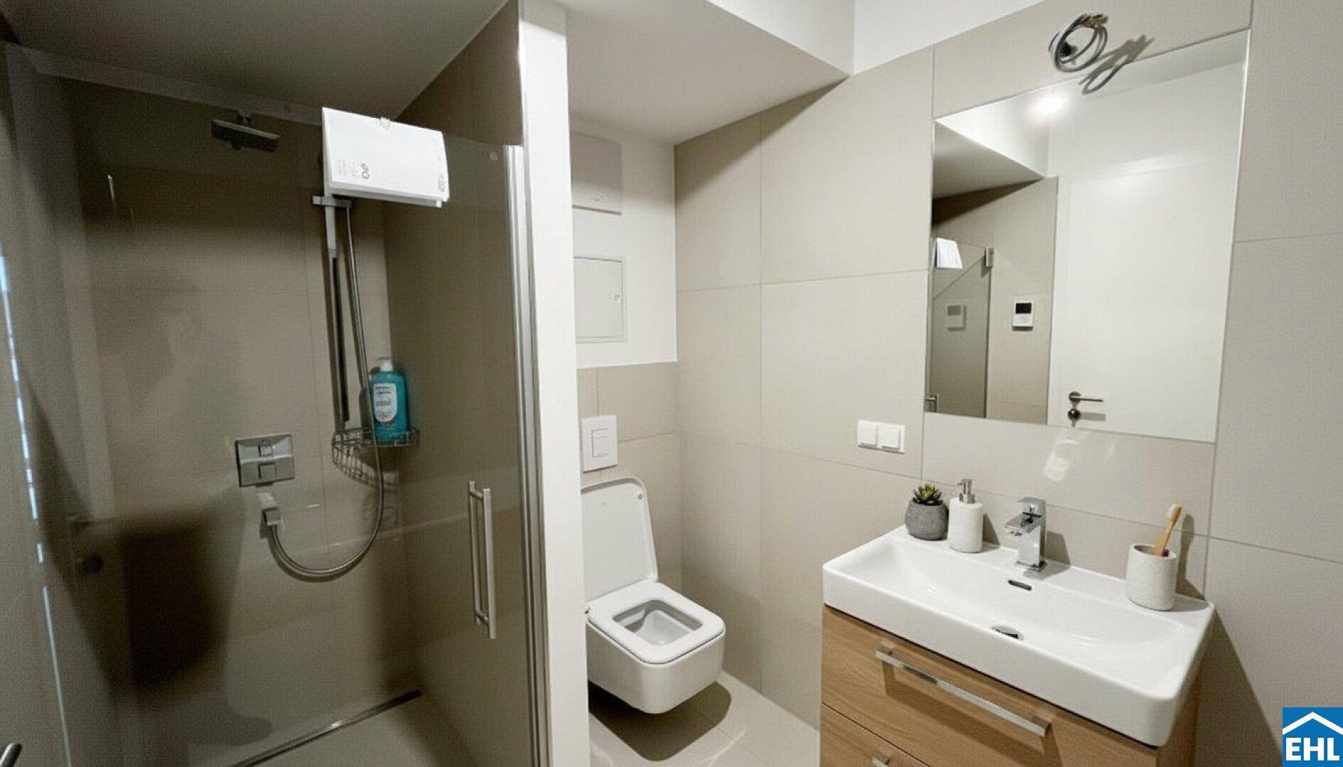 Modernes Badezimmer mit ebenerdiger Dusche, wandhängendem WC und Waschtisch mit Spiegelschrank.