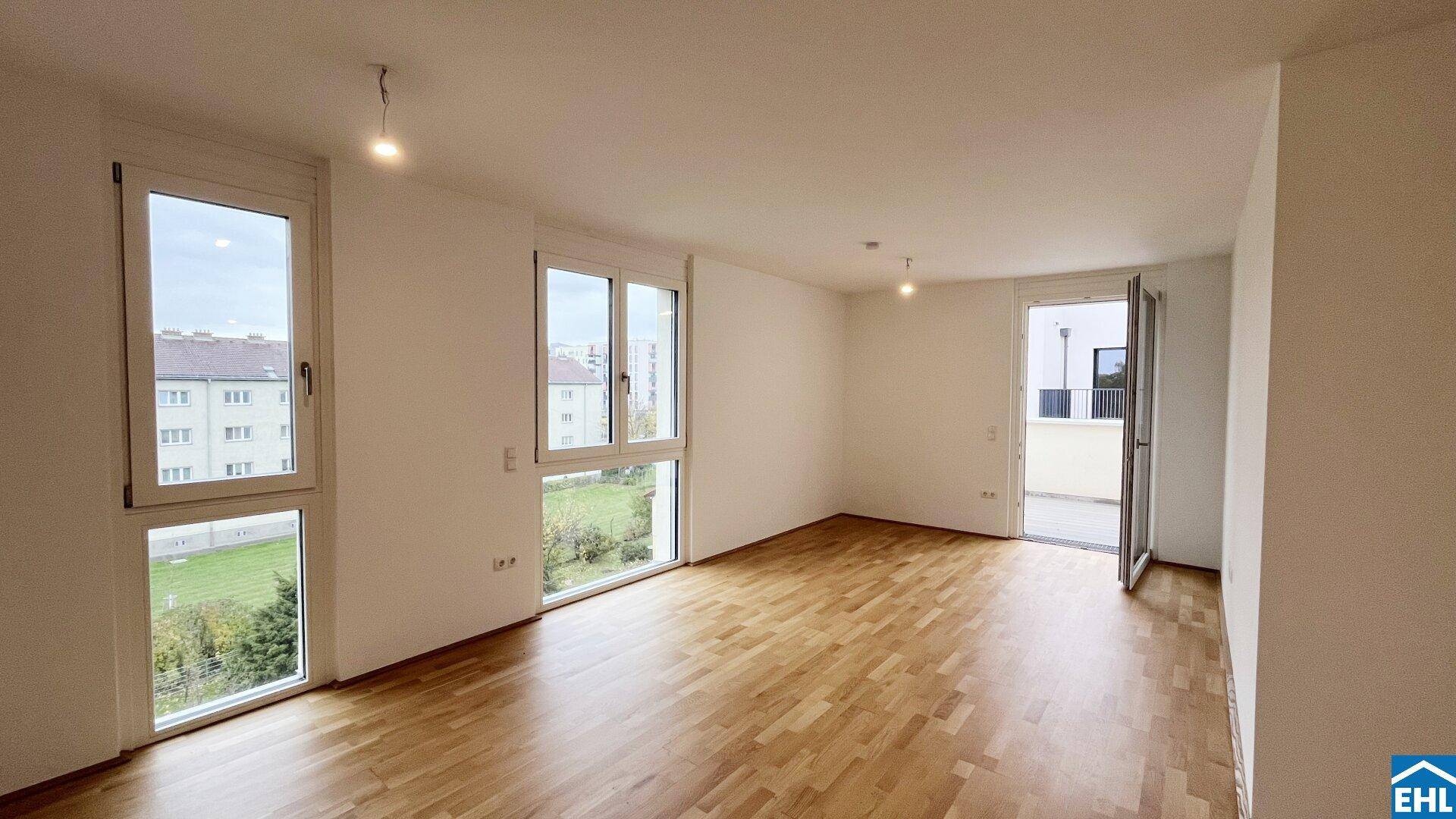 Geräumiger, unmöblierter Wohn- und Essbereich mit Holzboden und Terrassenzugang, ideal für offenes Wohnen.