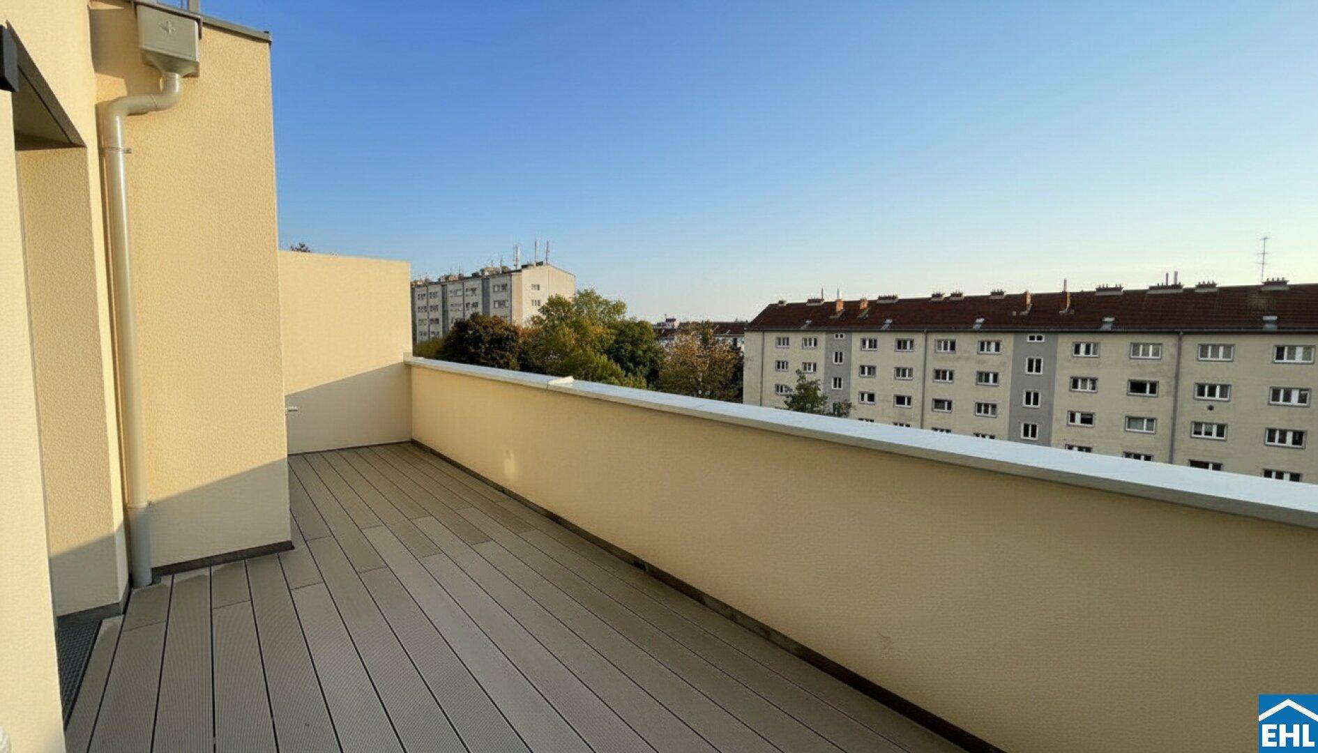 Geräumiger, leerer Balkon mit modernem Bodenbelag und weitem Blick über die städtische Umgebung.