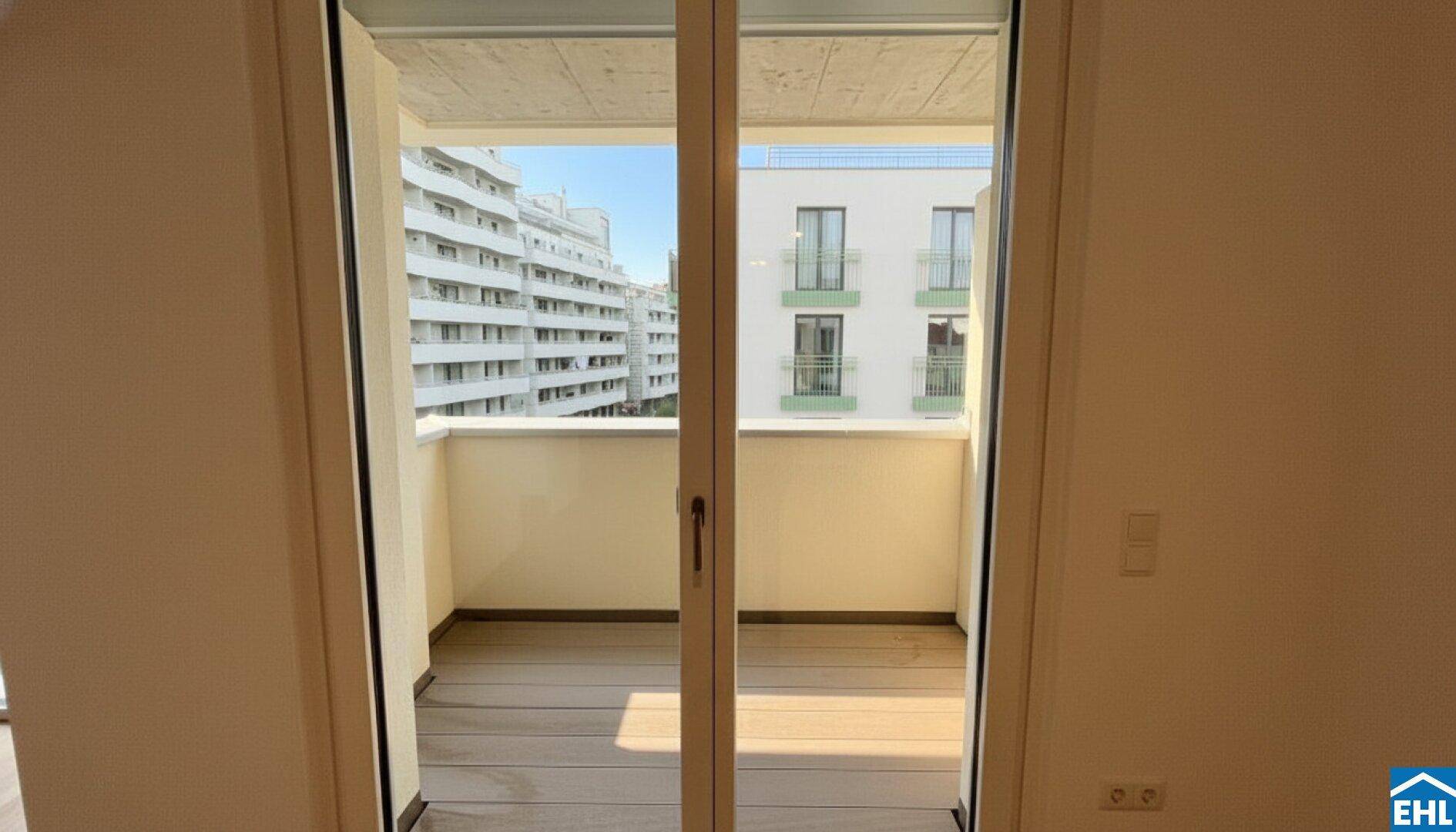 Balkon mit Holzboden und Blick auf die umliegenden Gebäude und die Stadt.