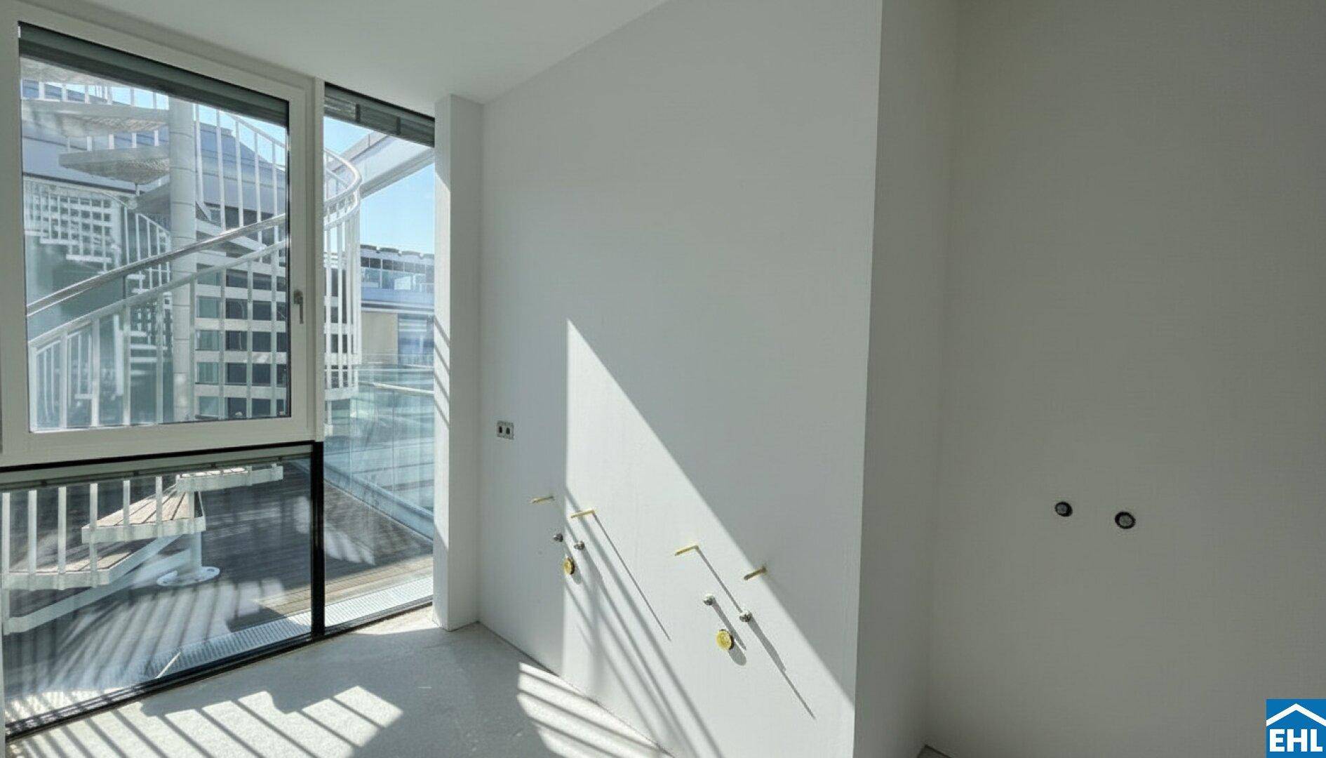 Leerer Raum mit Anschlüssen für ein Badezimmer und viel Tageslicht.