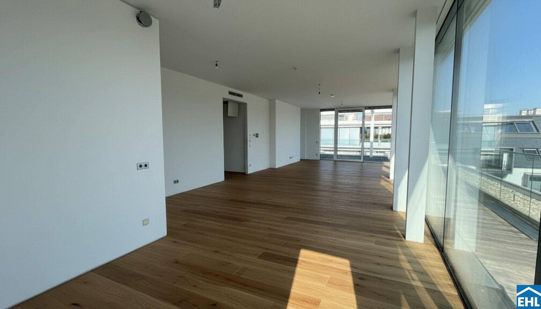 Heller Flur mit Holzboden und großen Fenstern, die viel Licht hereinlassen.