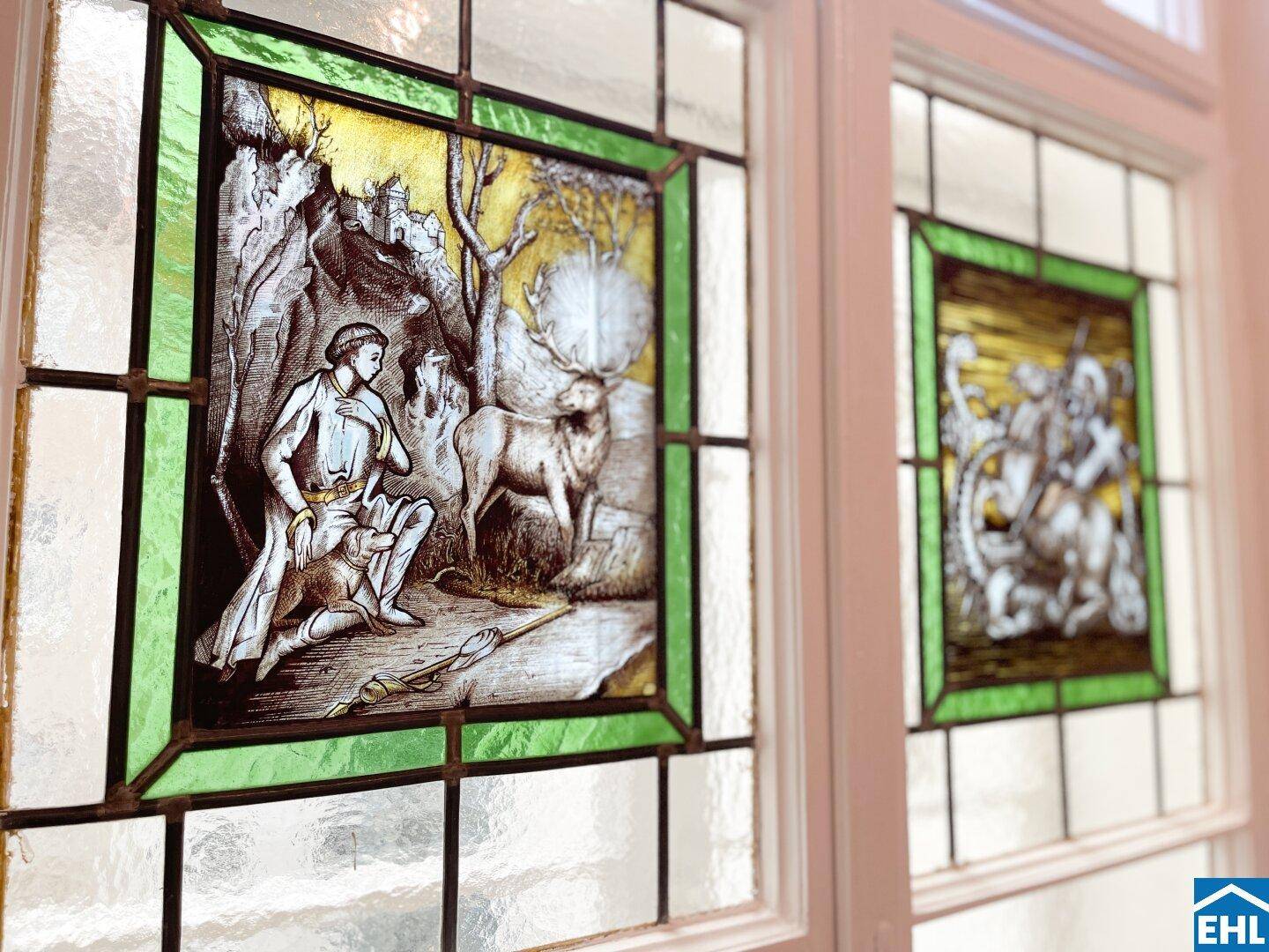 Detailaufnahme eines Fensters mit kunstvollen Buntglasverzierungen in traditionellem Stil.