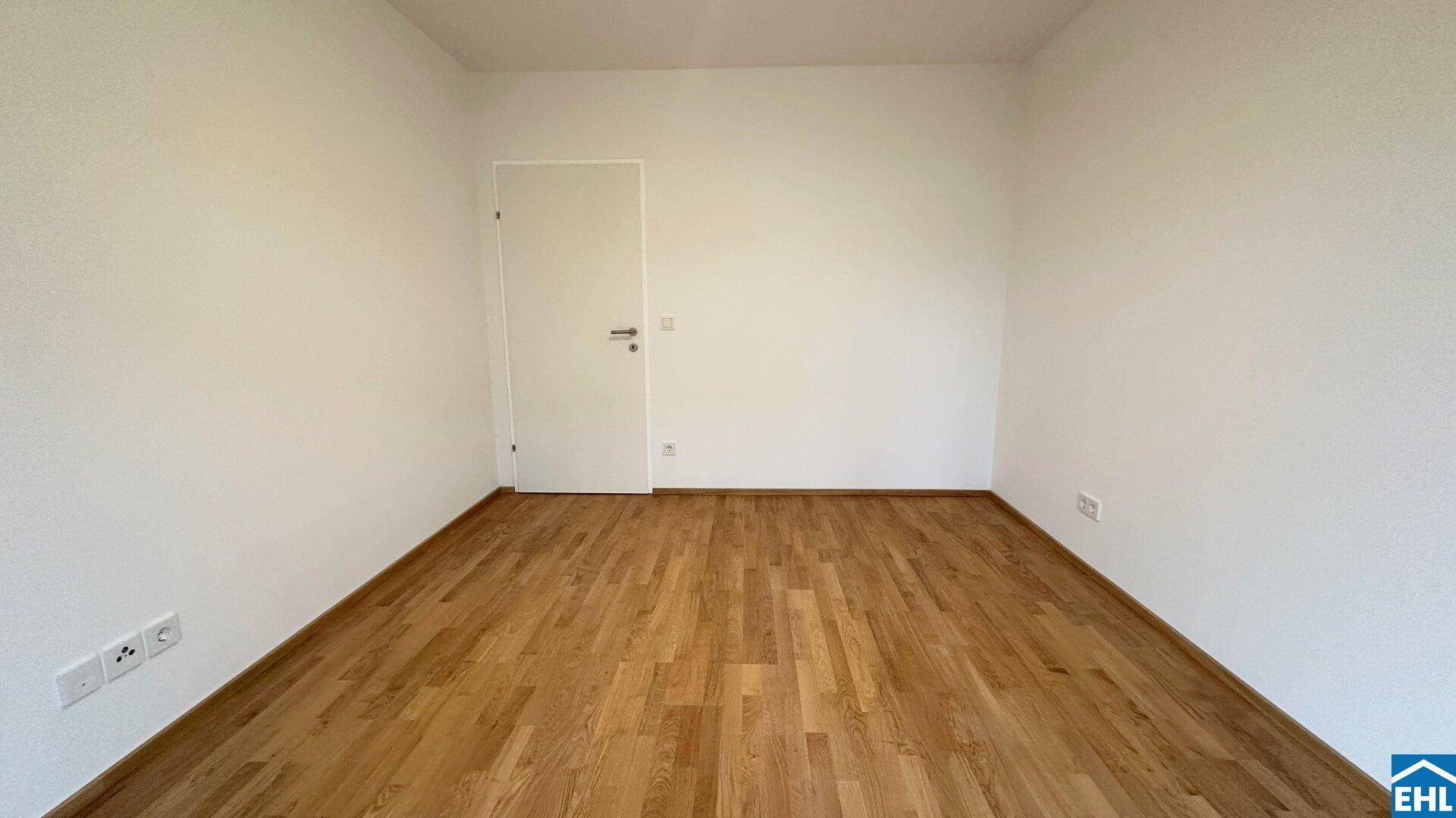 Heller Raum mit Holzparkettboden und weiß gestrichenen Wänden, ideal als Schlaf- oder Arbeitszimmer.