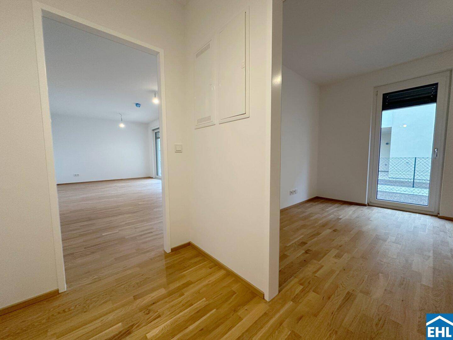 Heller Flurbereich mit Holzboden, der zu weiteren Räumen führt und einen modernen Wohnstil zeigt.