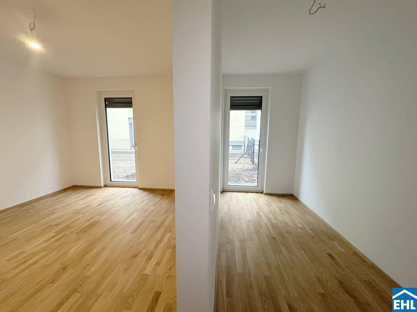 Heller Flur oder Übergangsbereich mit Parkettboden und Zugang zu weiteren Räumen.