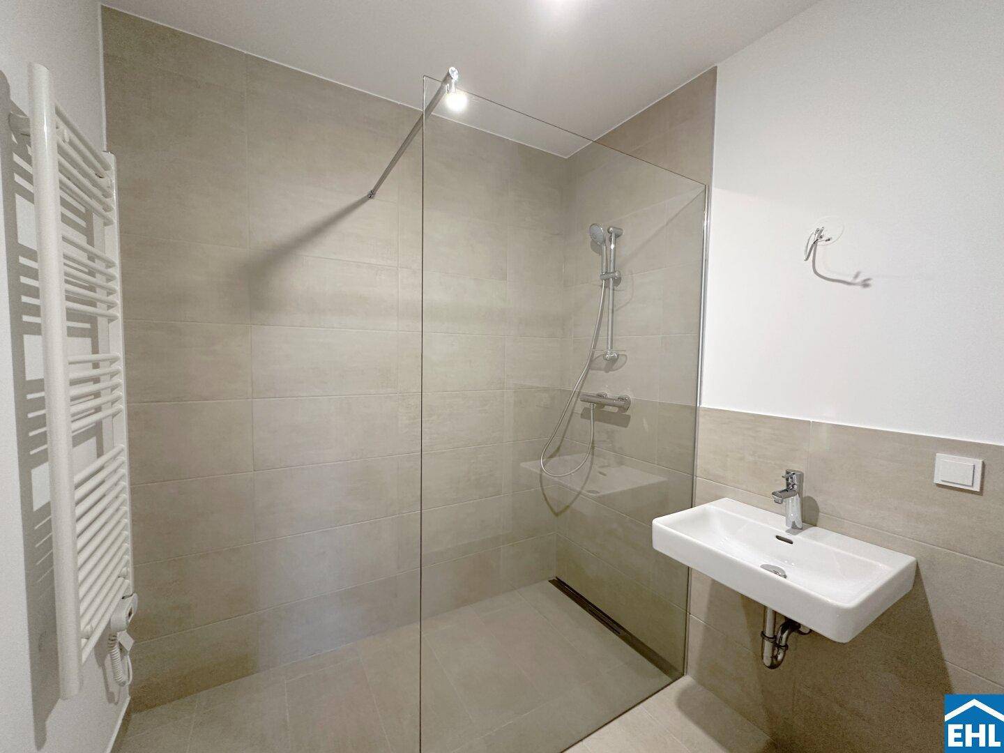 Modernes Badezimmer mit begehbarer Dusche, Wandfliesen und Handtuchheizkörper.