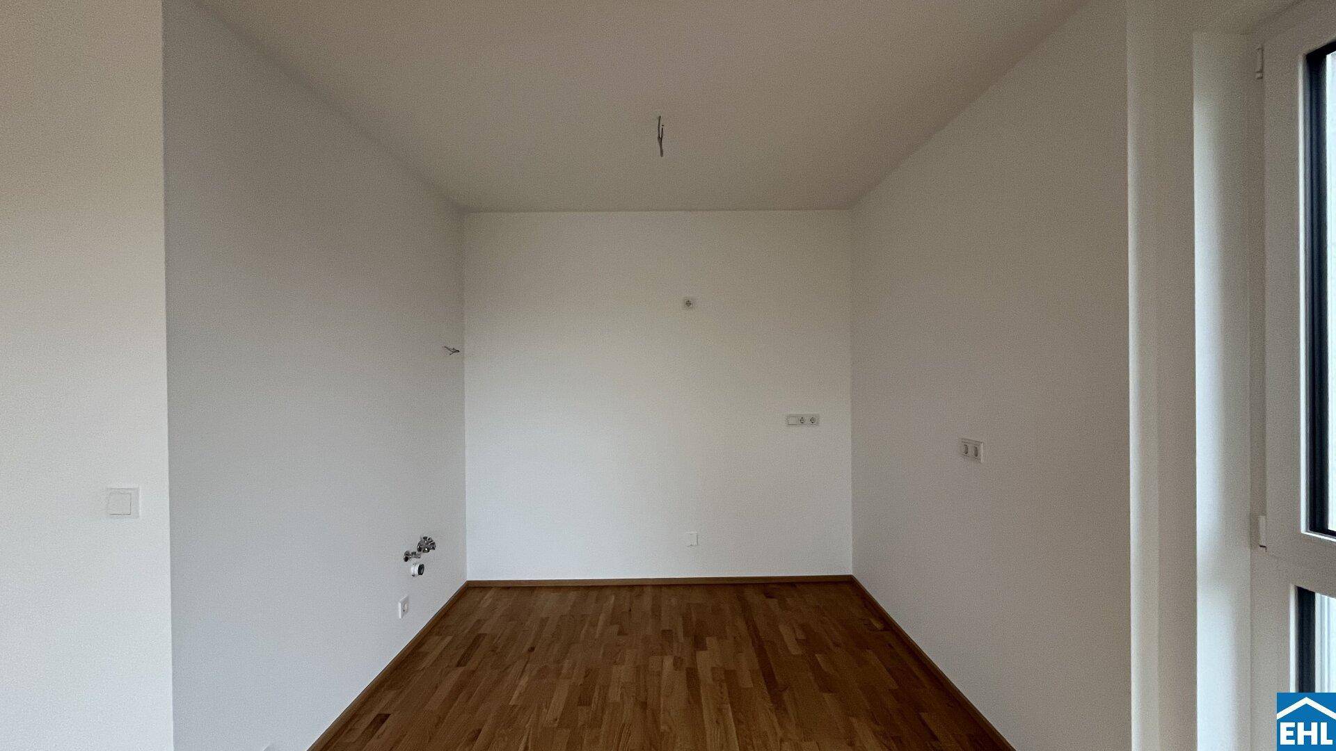 Leerer Raum mit Parkettboden und weiß gestrichenen Wänden, bereit zur individuellen Gestaltung.