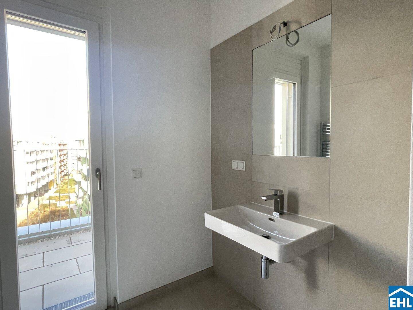 Modernes Badezimmer mit Einzelwaschbecken und Zugang zu einem französischen Balkon.