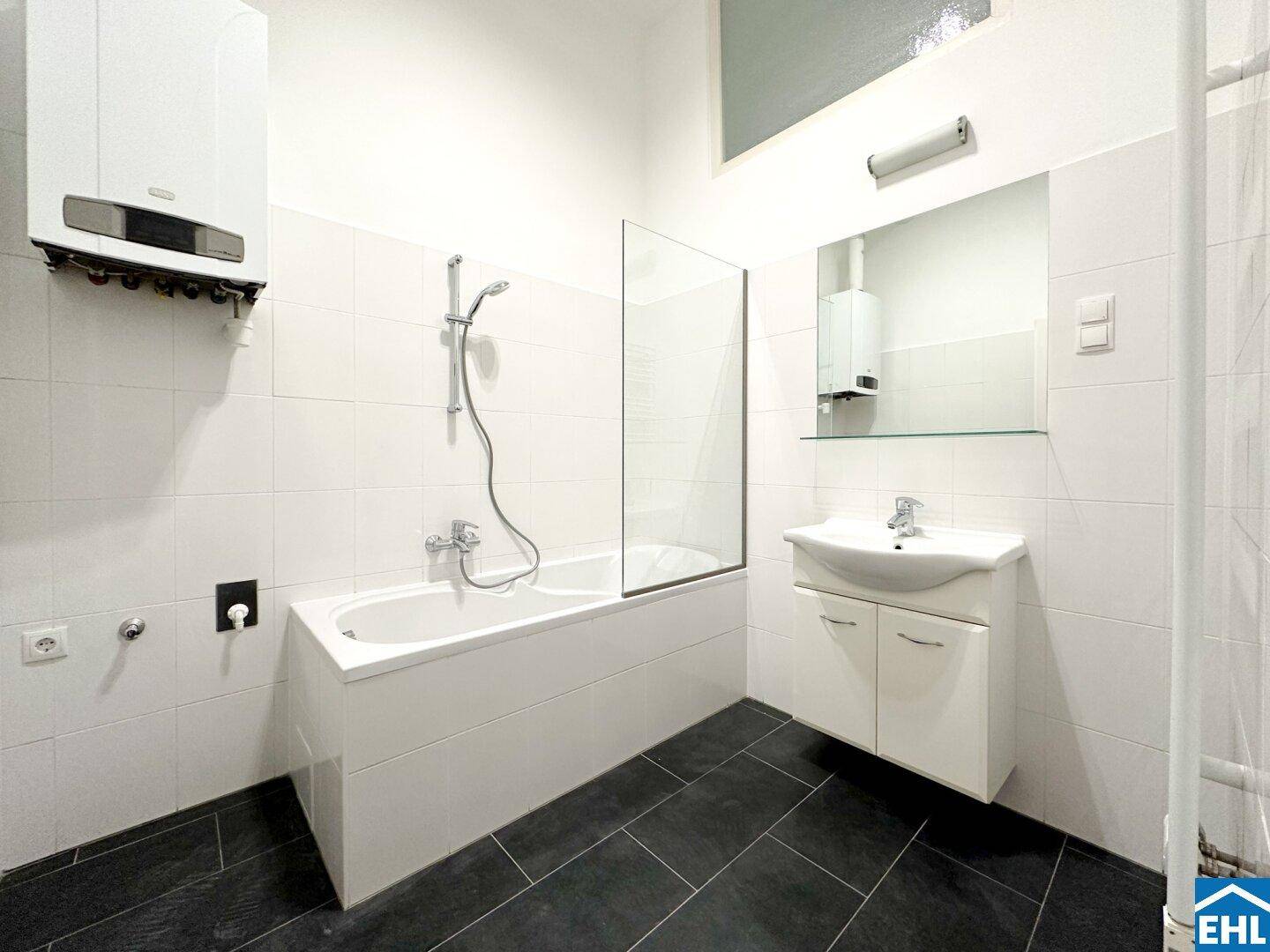 Modernes Badezimmer mit Badewanne, Duschfunktion und einem Waschbeckenunterschrank.