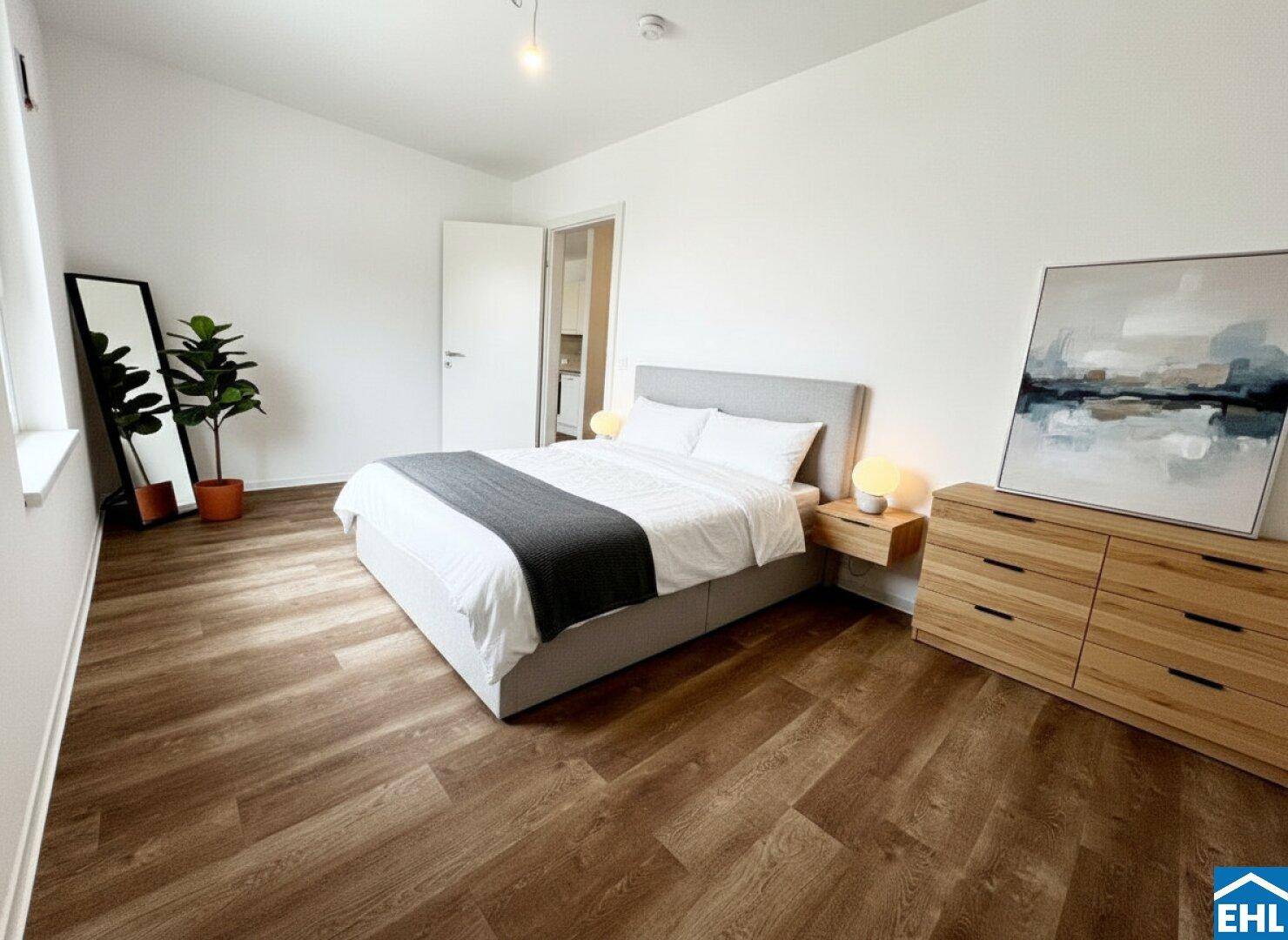 Gemütliches Schlafzimmer mit modernem Bett, Holzboden und Zugang zu einem weiteren Raum.