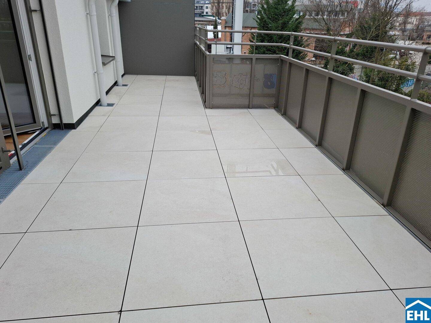 Geräumige, geflieste Terrasse mit Metallgeländer, ideal für Entspannung im Freien.