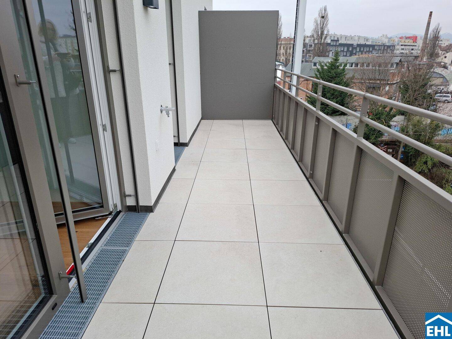 Geräumiger Balkon mit Fliesenboden und modernem Geländer, zugänglich von den Innenräumen.