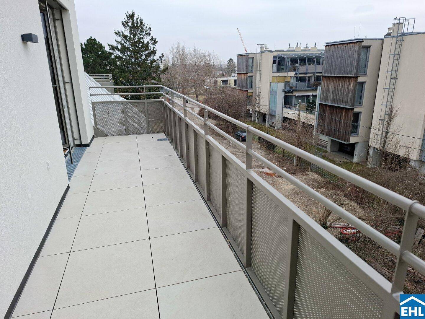 Geräumiger Balkon mit Fliesenboden und modernem Geländer, ideal für entspannte Stunden im Freien.