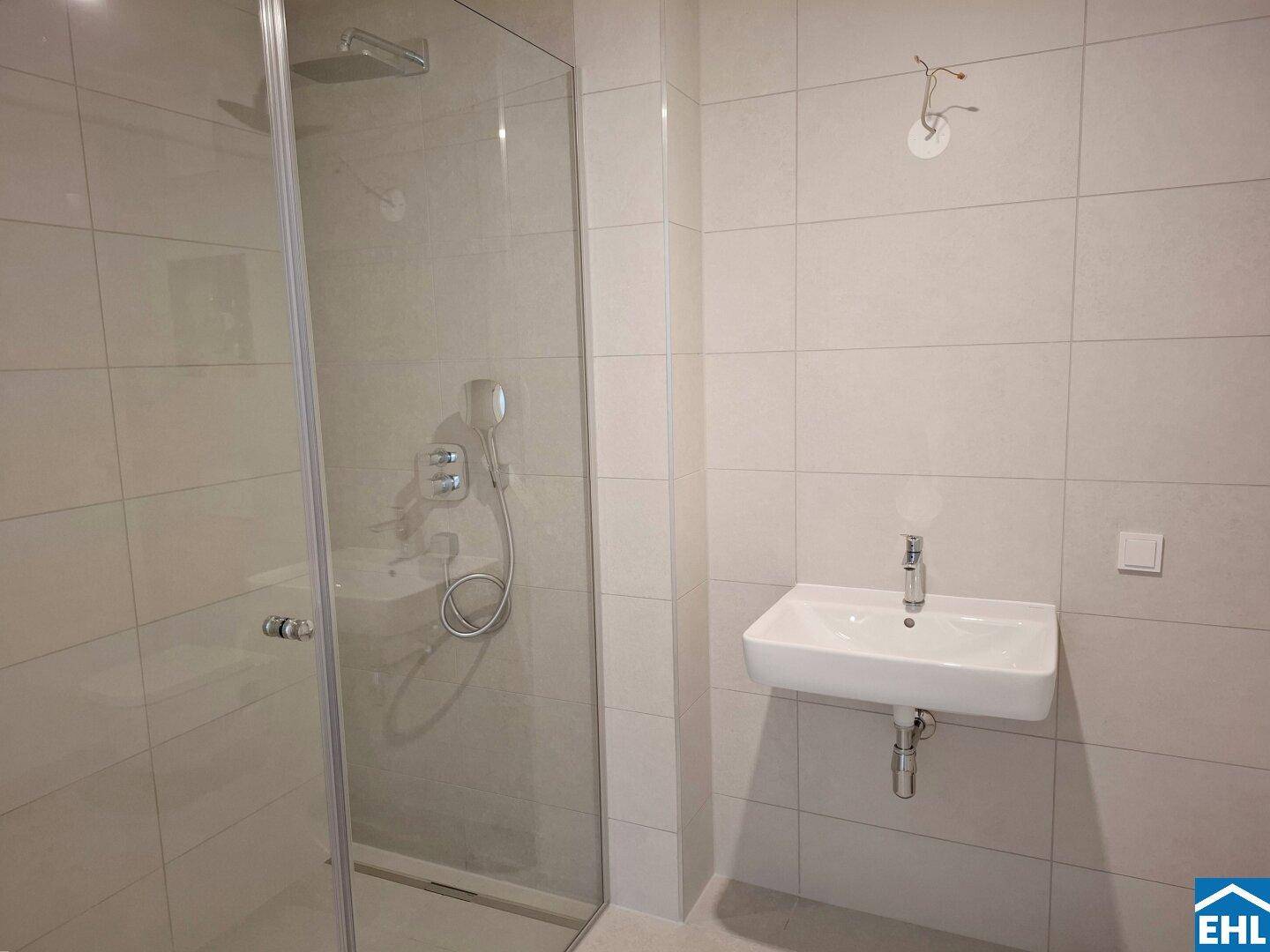 Modernes Badezimmer mit Duschkabine und einem einzelnen Waschbecken.
