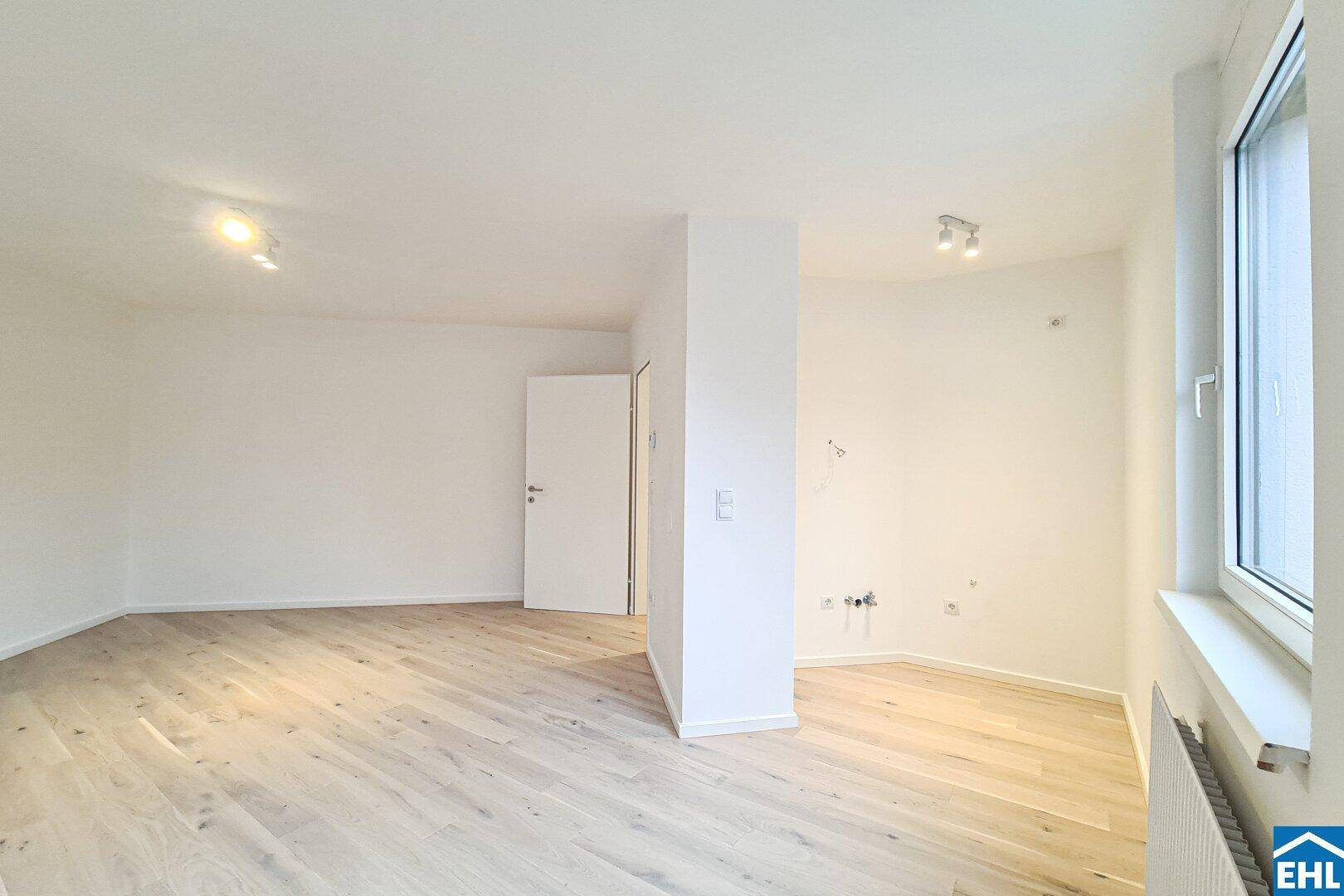 Weitläufiger, heller Raum mit Parkettboden und einem Fenster, ideal für flexible Einrichtungsmöglichkeiten.