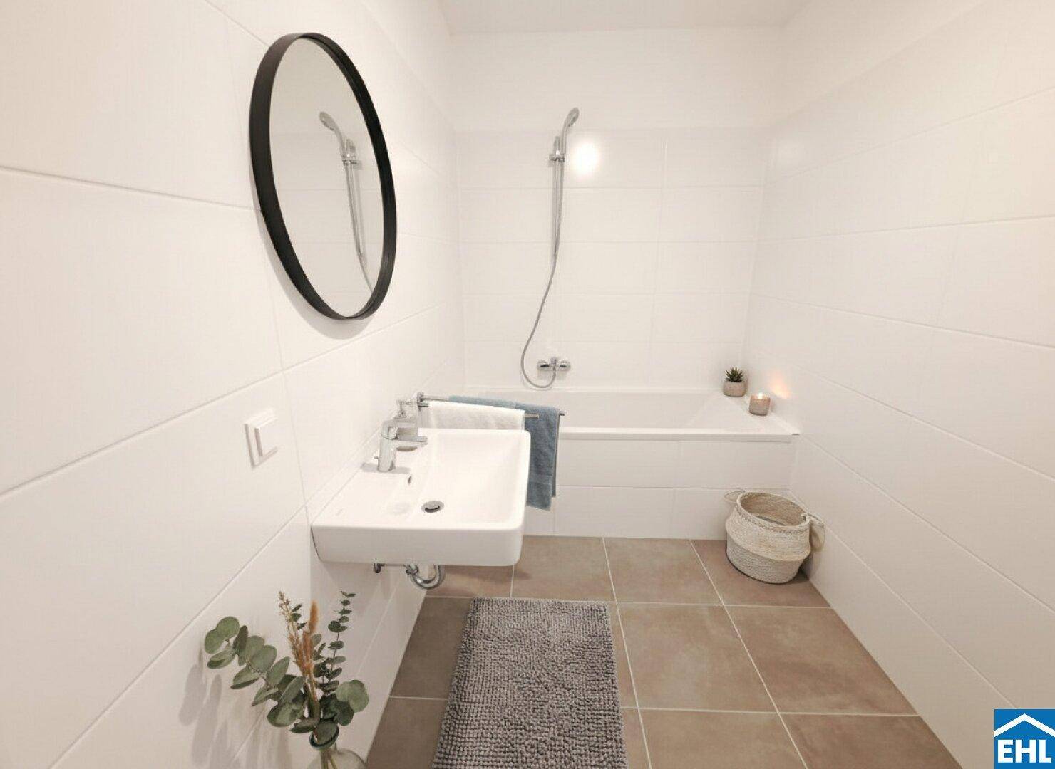 Helles Badezimmer mit Badewanne, modernem Waschbecken und Spiegel, einladend dekoriert.