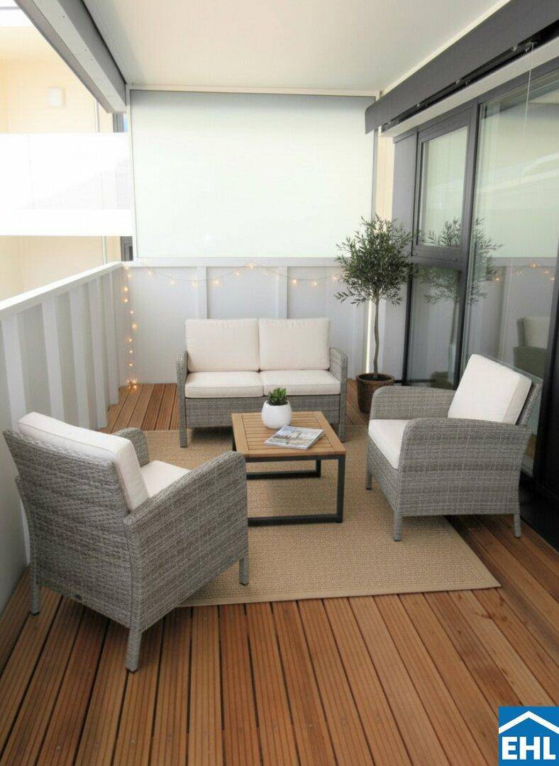 Gemütlicher Balkon mit Holzfußboden und bequemen Outdoor-Sitzmöbeln.