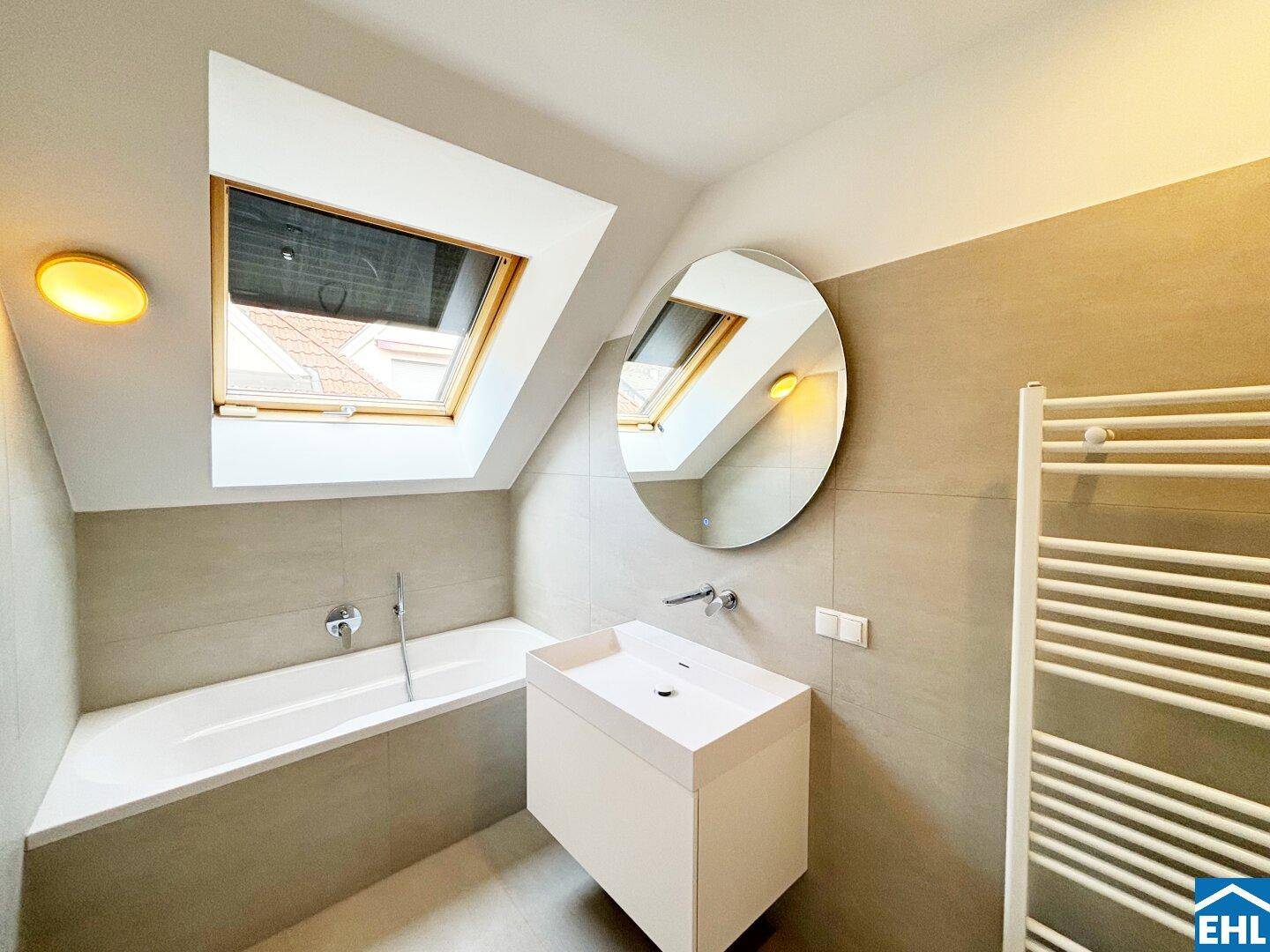 Modernes Badezimmer im Dachgeschoss mit Badewanne, Dachfenster und stilvollem Einzelwaschbecken.