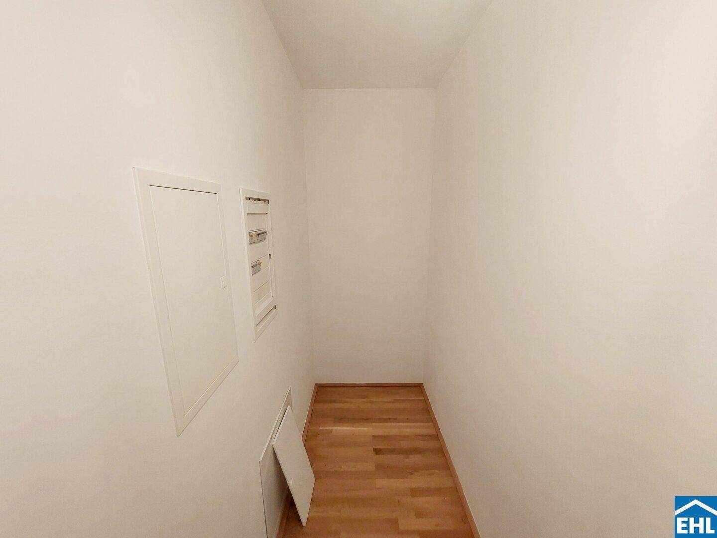 Kleiner Abstellraum mit hellem Parkettboden und Zugang zu den elektrischen Installationen des Hauses.