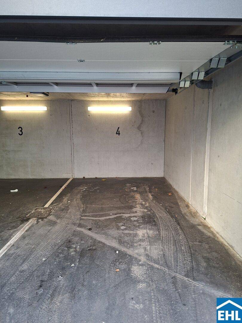 Geräumiger Tiefgaragenstellplatz mit Betonwänden und Beleuchtung, ideal für ein Fahrzeug.