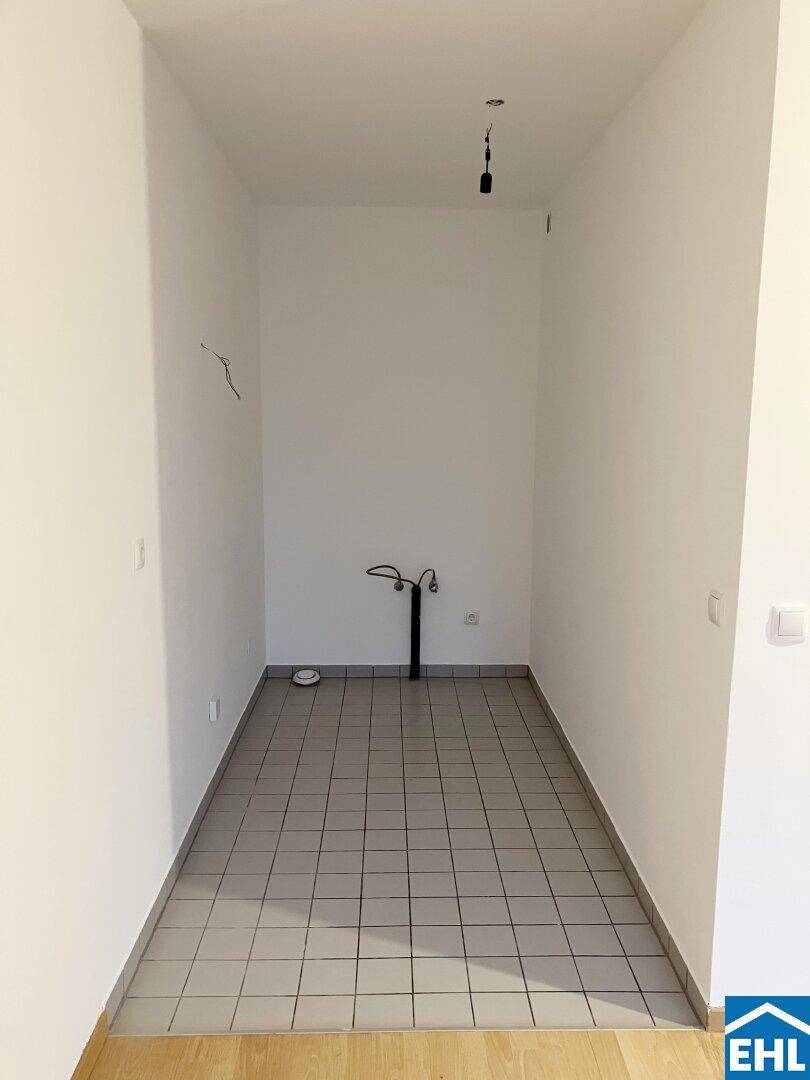 Schmaler Raum mit Fliesenboden und Wasseranschlüssen, ideal als Abstellraum oder Gäste-WC, in gutem Zustand.