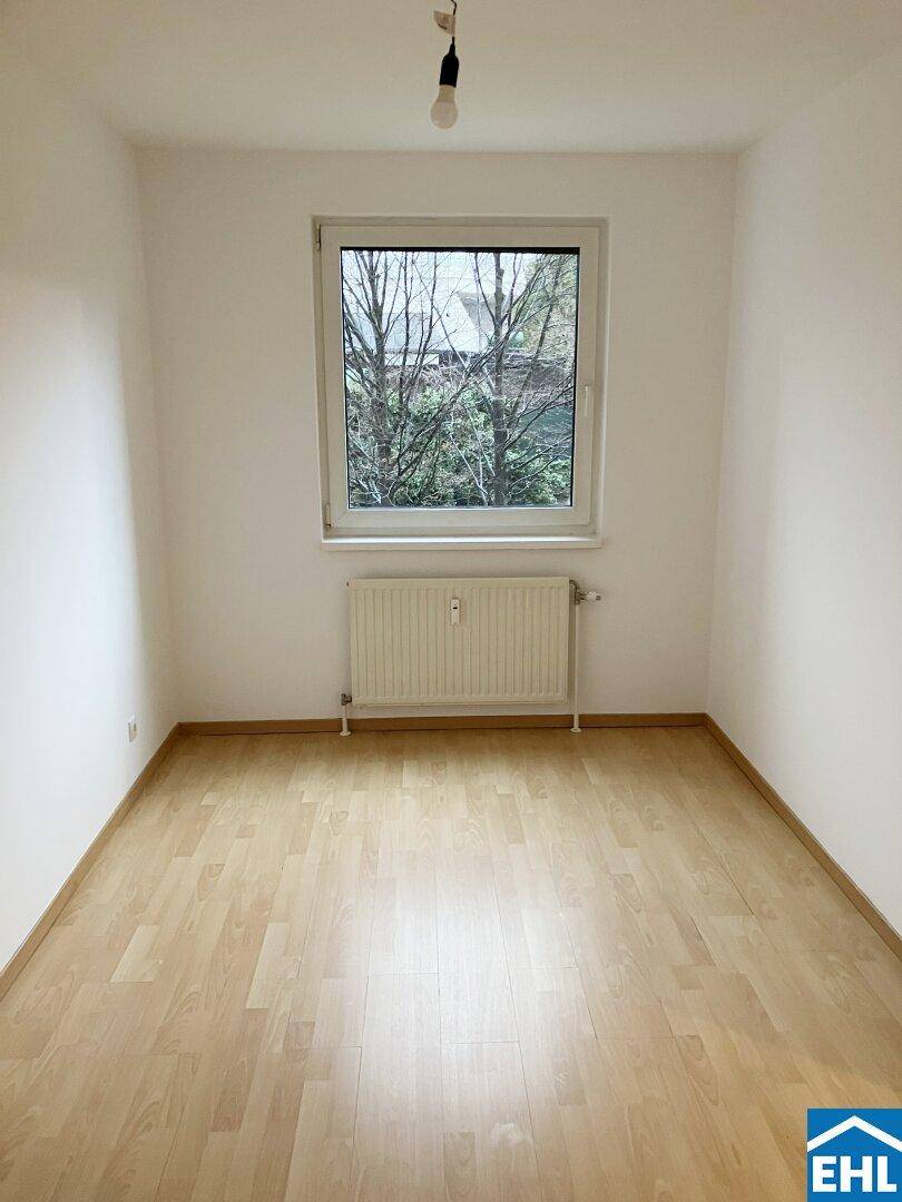 Gemütliches Schlafzimmer mit Parkettboden, einem Fenster und Heizkörper, in gepflegtem Zustand.