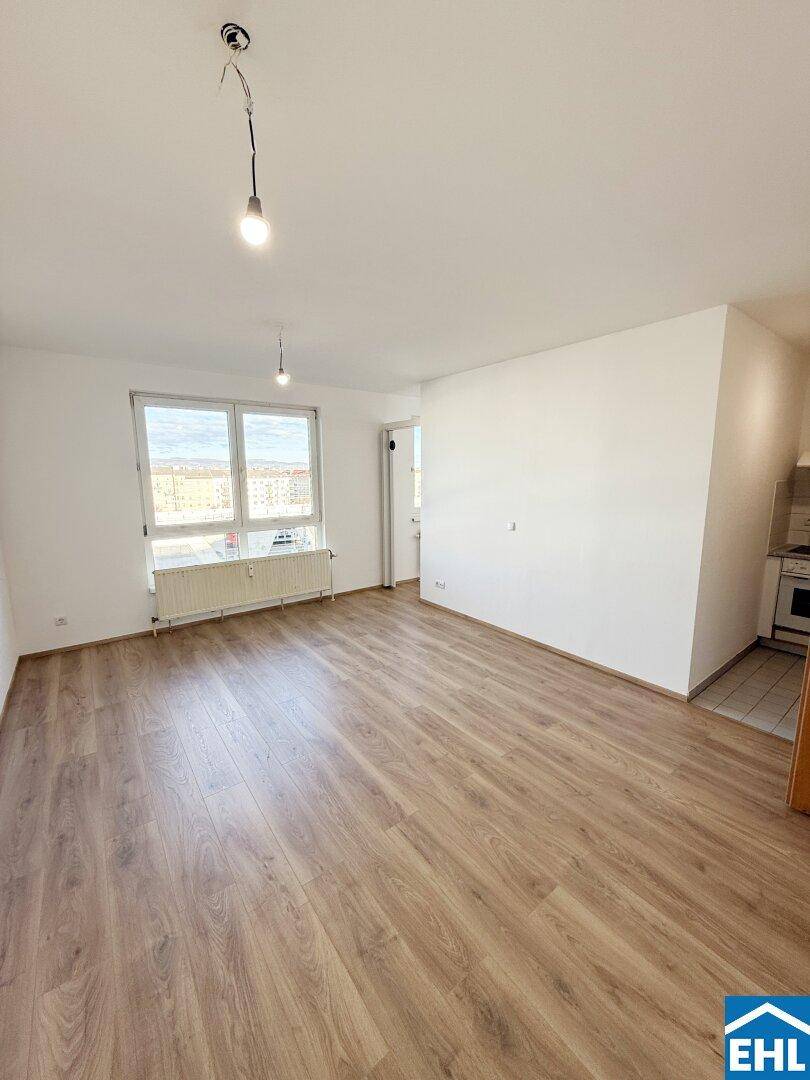 Geräumiges, helles Zimmer mit Laminatboden und Blick nach draußen, ideal für Wohnzwecke.