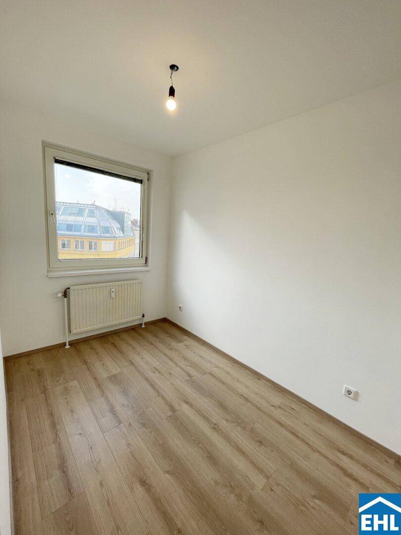 Kleineres, helles Zimmer mit Laminatboden und Fenster, ideal als Schlaf- oder Arbeitszimmer.