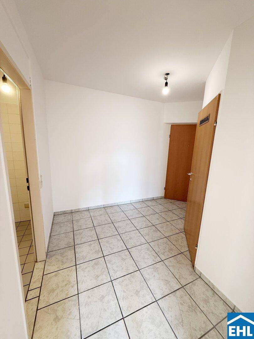 Eingangsbereich mit Fliesenboden und Zugang zu weiteren Räumen der Wohnung.